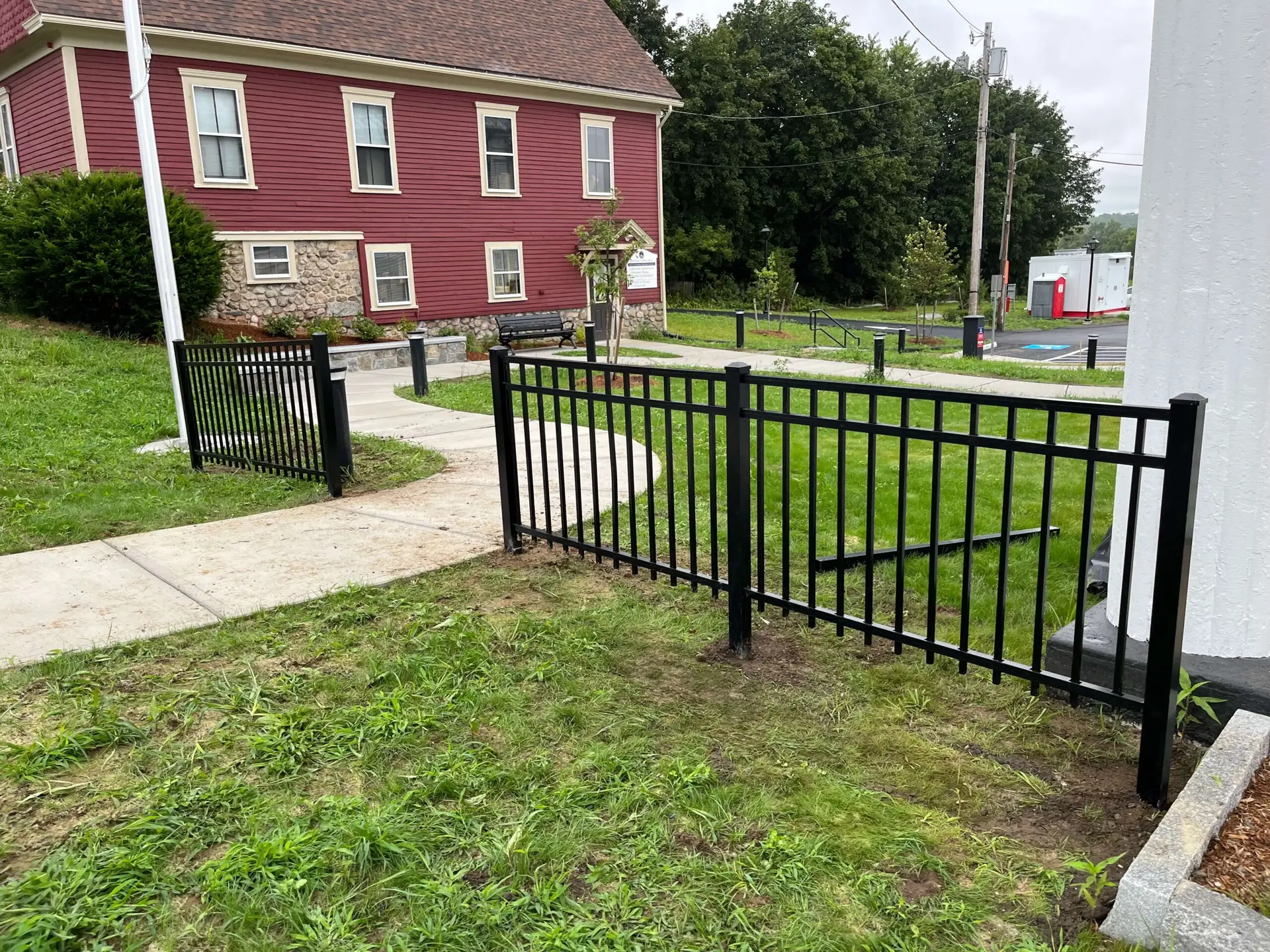 Ornamental aluminum fencing in West Newbury, MA, showcasing a refined design with a black finish, complementing the estate-style property and surrounding landscape.