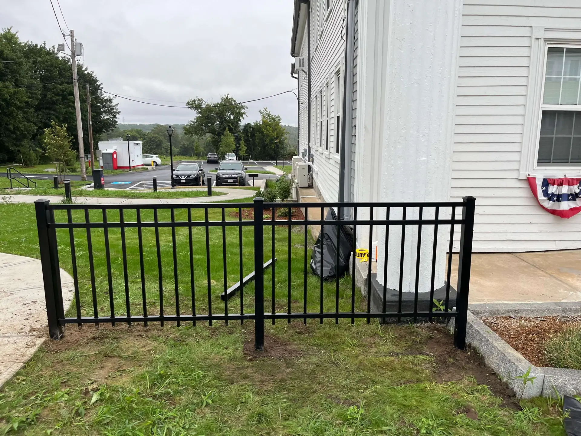 Heavy-duty black ornamental aluminum fencing installed beside a building in Newburyport, showcasing a polished appearance and enhancing property security.