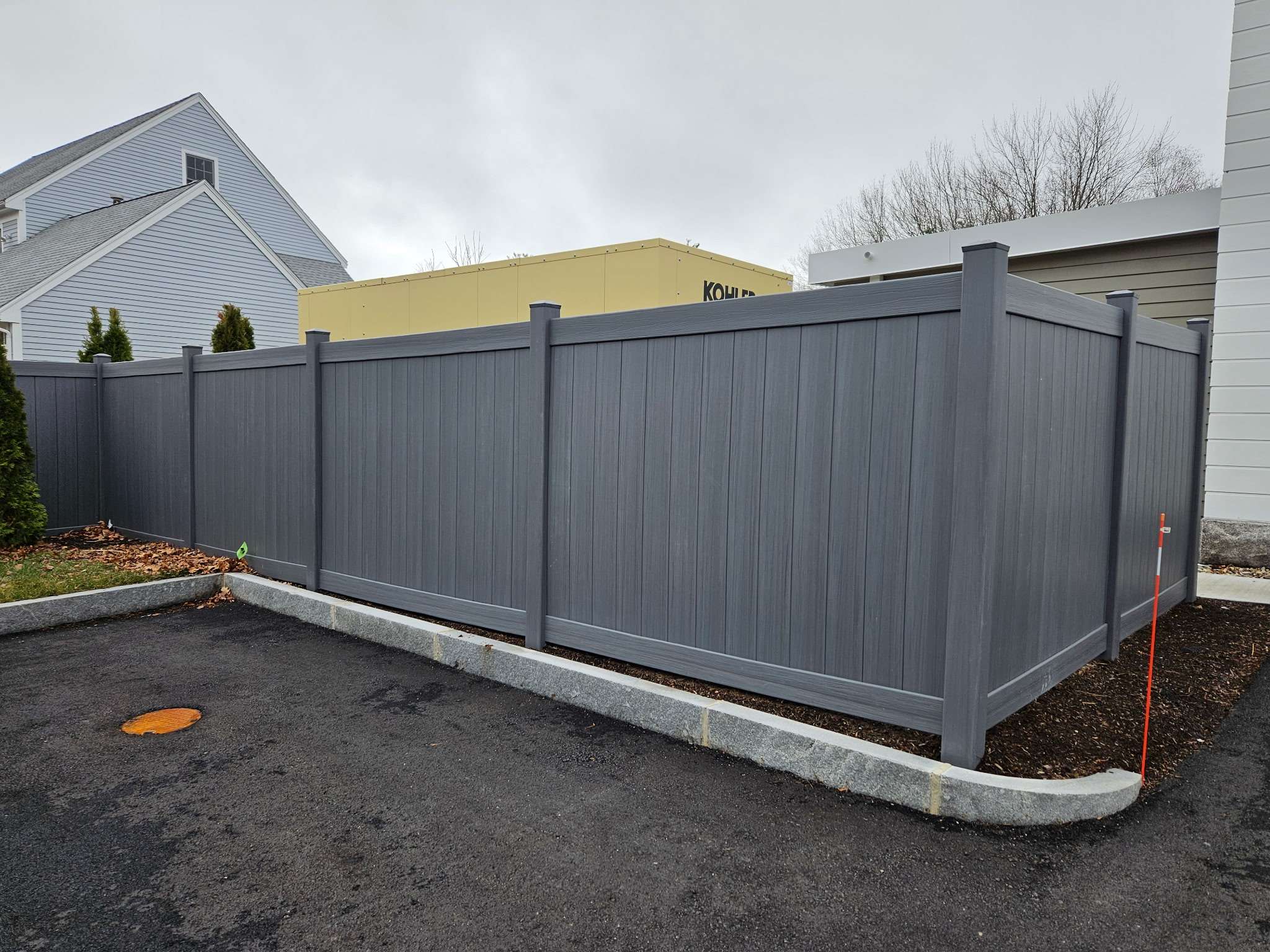 Vinyl privacy fencing in gray, complementing residential architecture, with a focus on low-maintenance durability for Salisbury properties.
