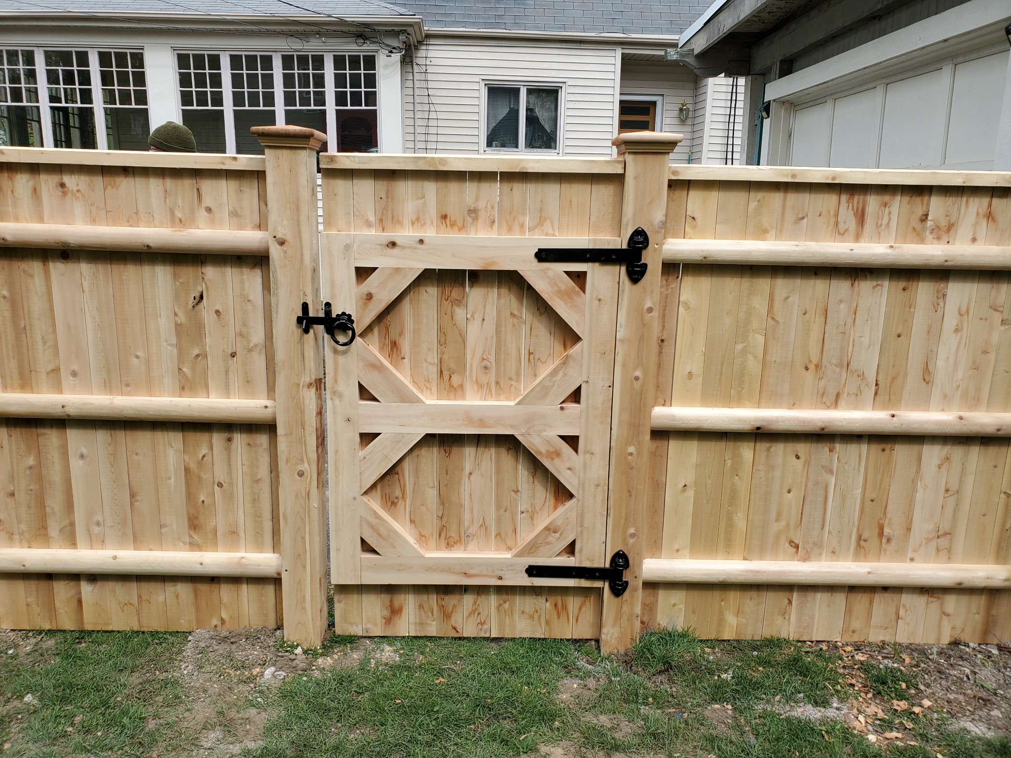 Cedar privacy fence with custom gate, showcasing quality craftsmanship in residential fencing installation by Olympic Fence.