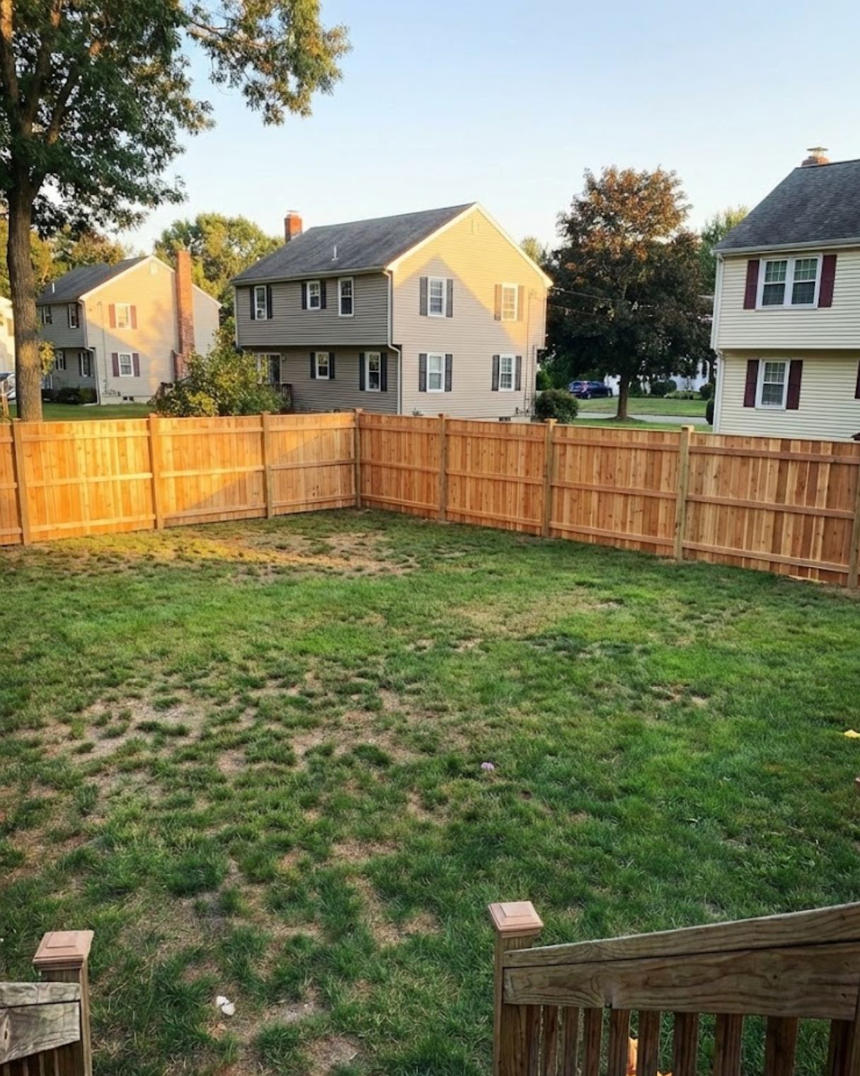 Wood privacy fence installation enclosing a grassy yard, enhancing security and aesthetics for residential property.