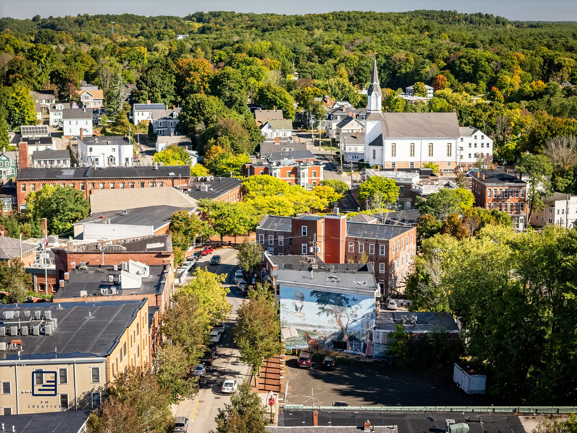 Aerial view of downtown Amesbury, Massachusetts, showcasing local architecture and the historic church, served by Olympic Fence Company.