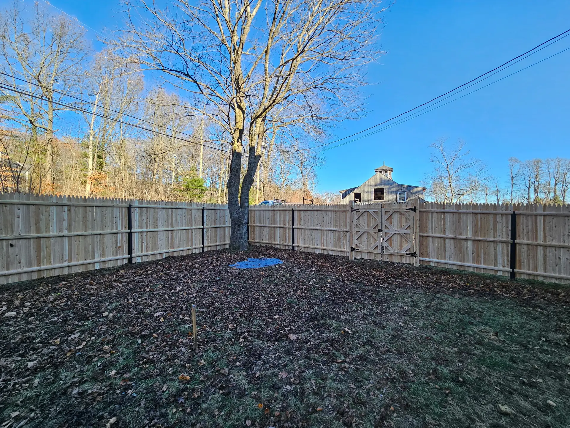 Cedar privacy fence installation by Olympic Fence Company in Merrimac, featuring wood-on-steel posts and a square gate.