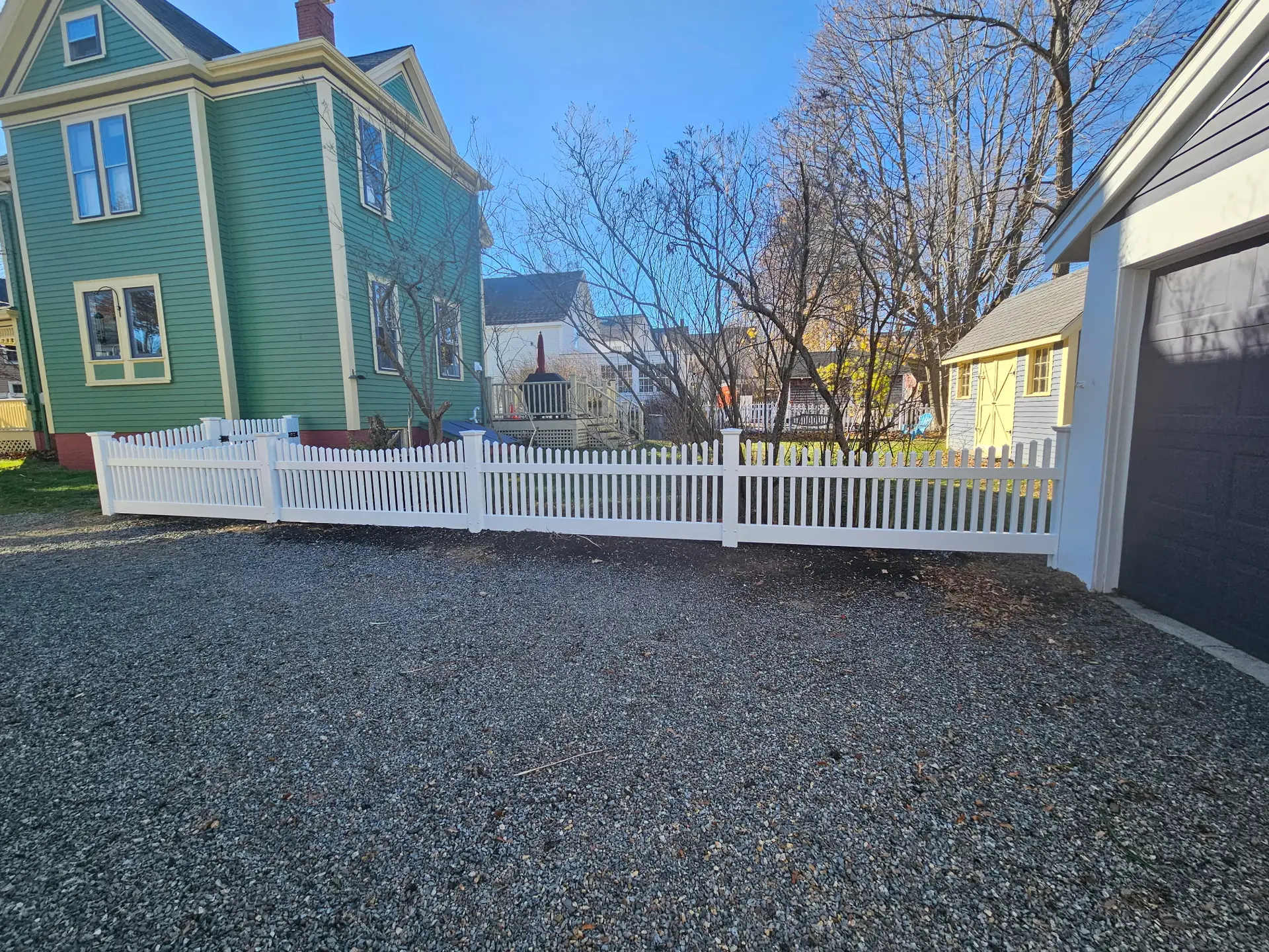 White vinyl scallop top fence installed by Olympic Fence Company in a North Shore residential yard.
