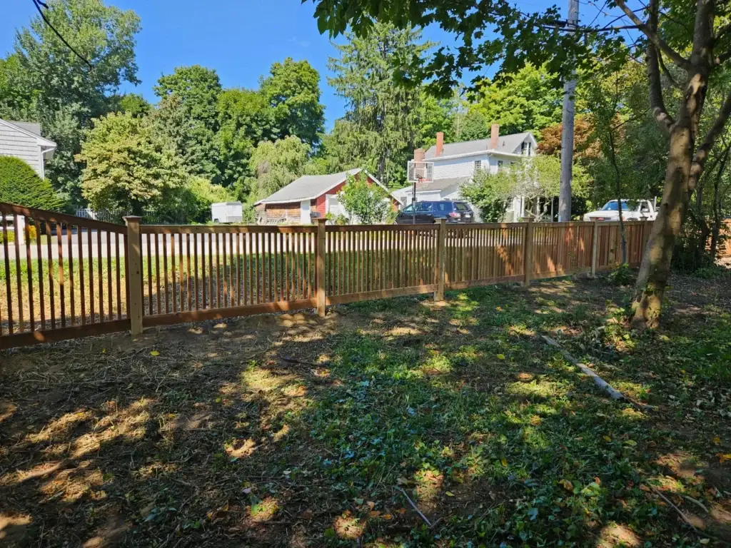 Newly installed wooden fence in a Newburyport residential yard, showcasing Olympic Fence Company's local expertise and lifetime workmanship warranty.