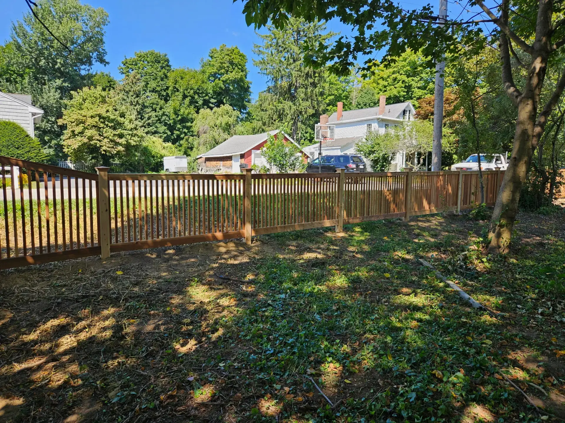 Wooden fence surrounding a residential property in Newburyport, showcasing craftsmanship and local landscaping, emphasizing Olympic Fence Co.'s installation expertise.