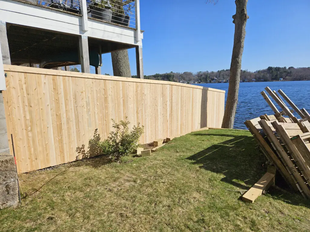 Wooden fence along a grassy area by the water