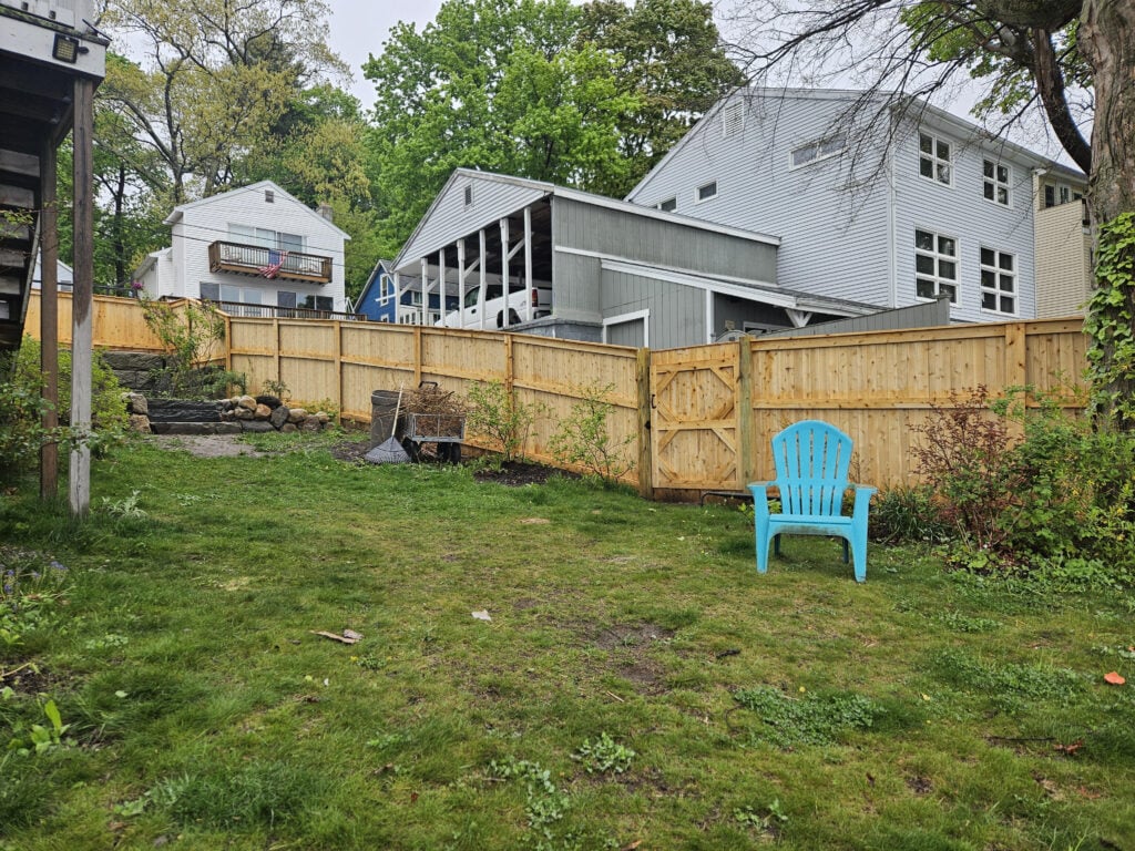 Backyard with green grass and a wooden fence